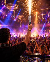 DJ raising a spark wand in a nightclub